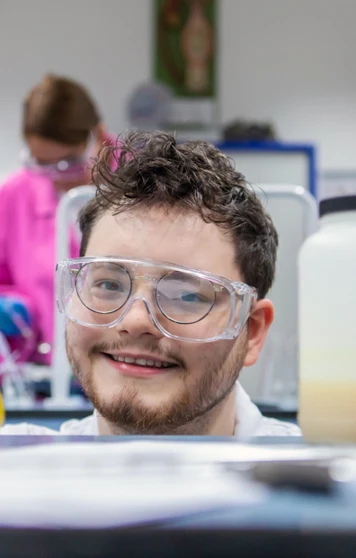 Science student smiling and holding a flask with yellow liquid in the laboratory at Glasgow Kelvin College Science student smiling and holding a flask with yellow liquid in the laboratory at Glasgow Kelvin College